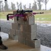 Vivid purple Aussie made rifle shooting gear on concrete bricks at an outdoor shooting range.