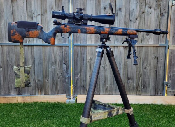 MANAEL Ultralite Hunter Arca Swiss Rail-Tikka Rifle with scope on a tripod, Australian-made shooting gear, outdoor setup, custom camouflage design.