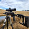 Precision Australian-made rifle shooting gear with scope on a tripod in outdoor landscape.